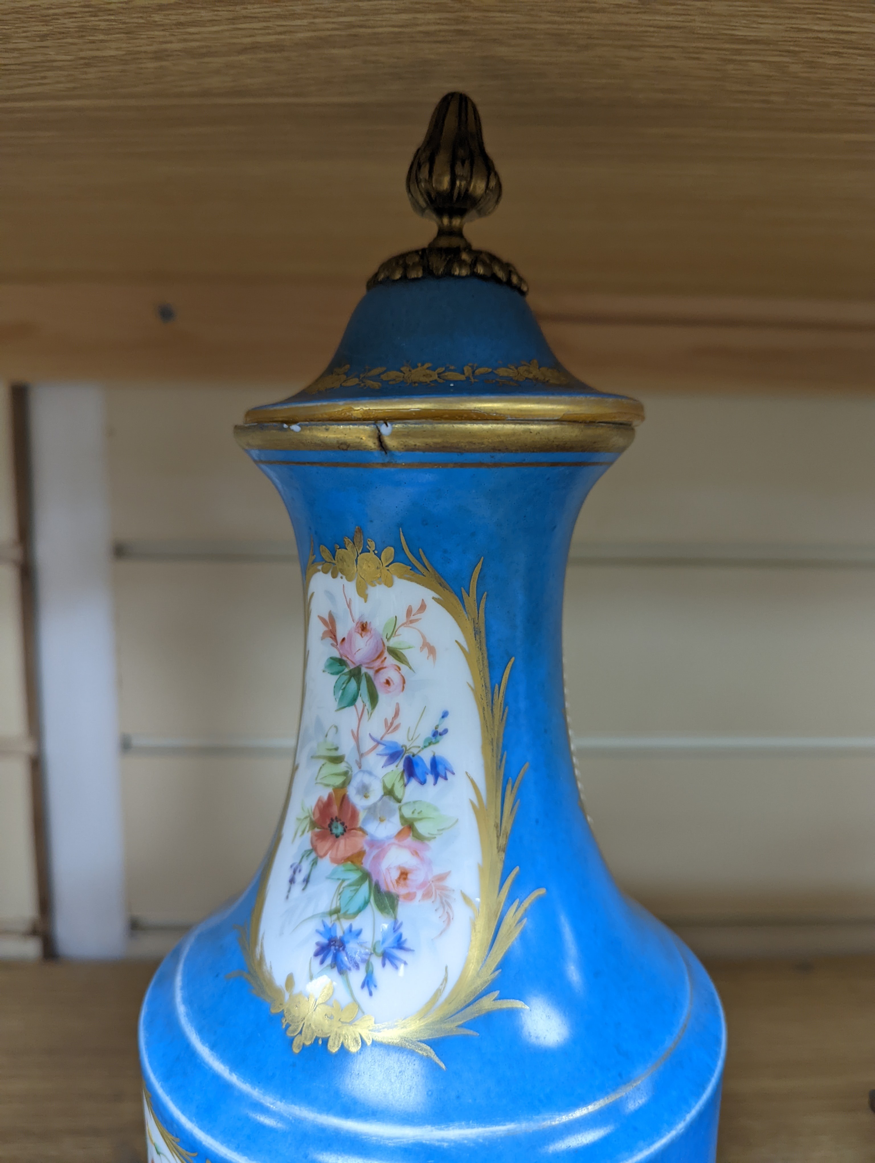 A pair of Sevres style porcelain bleu celeste ground vases and covers, 34cm